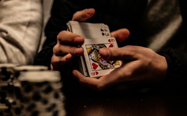 Person holding a deck of playing cards.